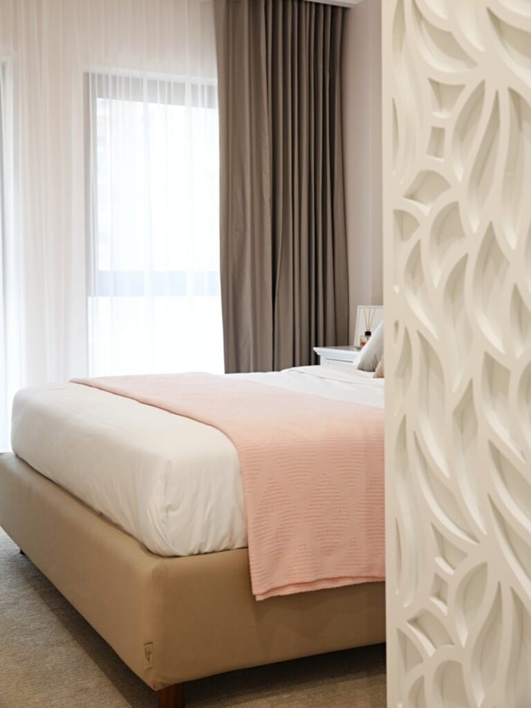 Fotografie dormitor amenajat in stil neoclasic cu accente de roz si alb.