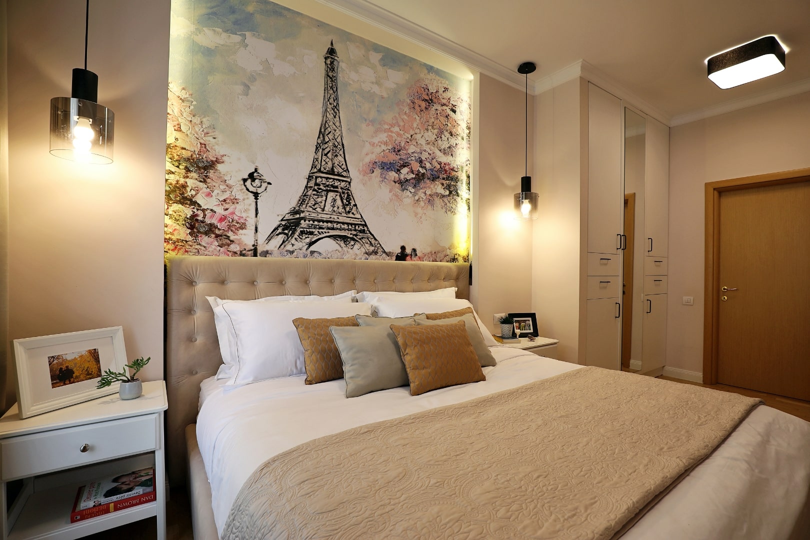 Design interior pentru un dormitor cu un tapet care reprezinta o imagine cu turnul eiffel.