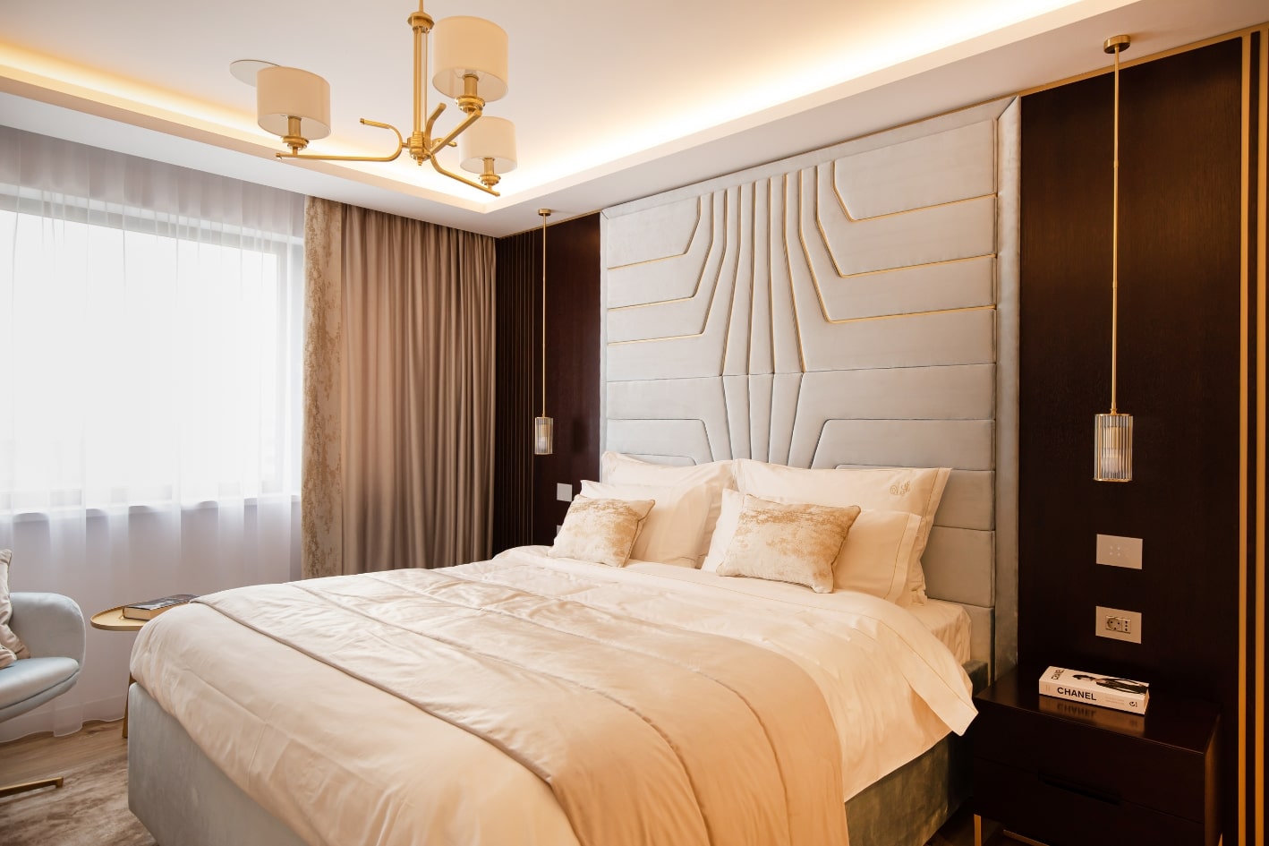 Design interior pentru un dormitor matrimonial cu un perete de accent cu detalii aurii si un pat mare.