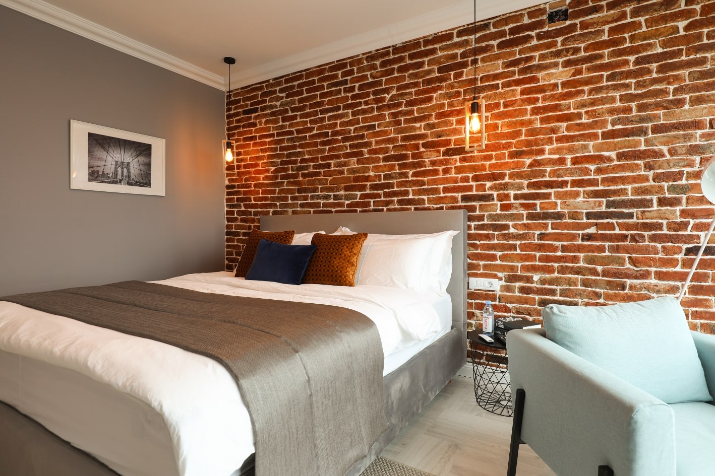 Amenajare dormitor in stil industrial cu un perete de caramida aparenta