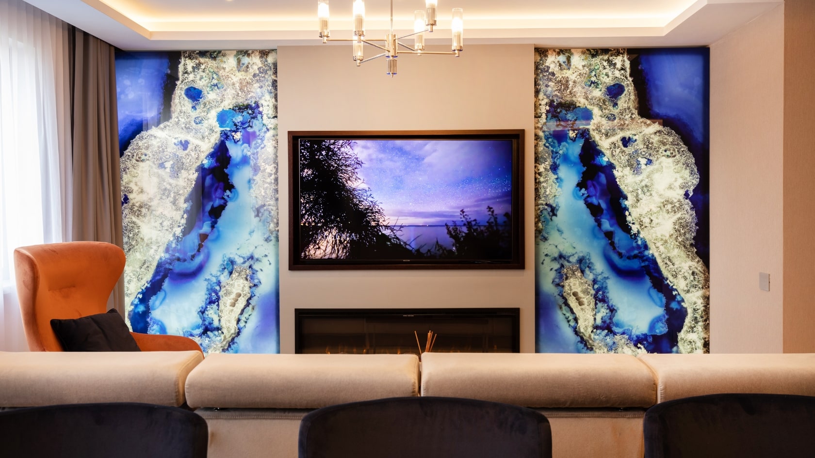 Living amenajat in stil modern, cu un televizor pe perete si doua placi de marmura albastra.